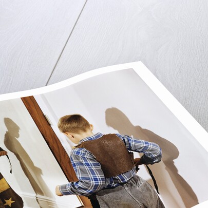 Boy Trying on Cowboy Duds by Anonymous