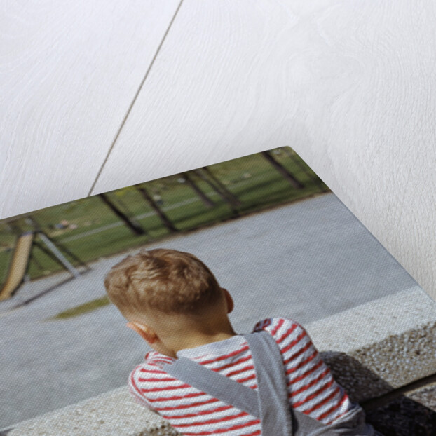 Boy Standing with Kitten in Schoolyard by Anonymous