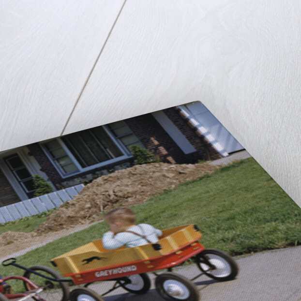 Boy Riding Tricycle and Towing Wagon by Anonymous