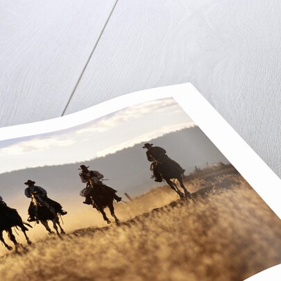 Cowboys Galloping Horses in Field by Anonymous