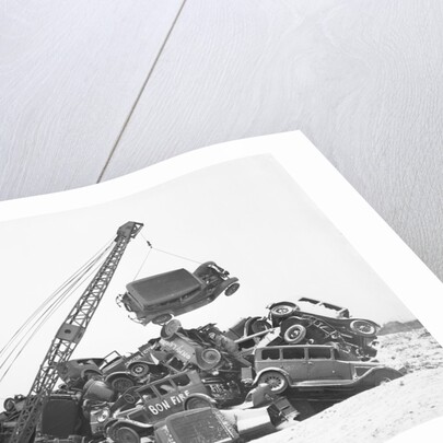 Crane Stacking Up Old Cars to be Burned in a Bonfire by Anonymous