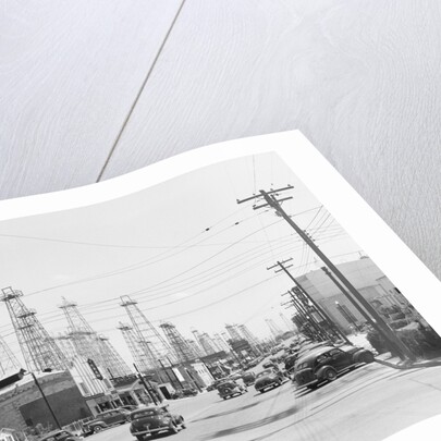 Clusters Of Oil Derricks Along Street by Anonymous