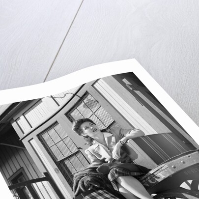 Woman Sitting on Luggage Trolley by Anonymous