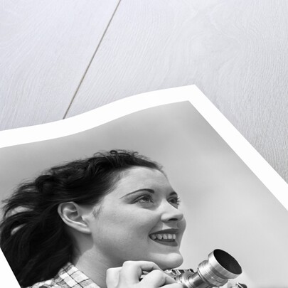 Woman Smiles as She Holds Camera by Anonymous