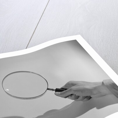 Hand Holding a Magnifying Glass by Anonymous