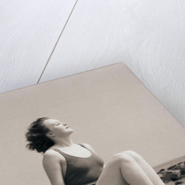 Young Woman Sitting on Beach Rocks by Anonymous