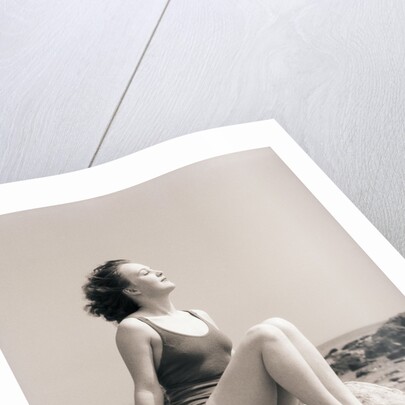 Young Woman Sitting on Beach Rocks by Anonymous
