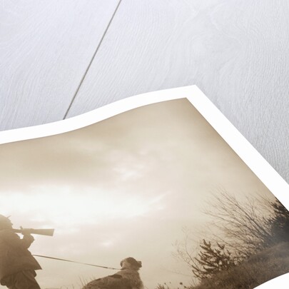 Silhouette of Hunter with Bird Dog Under Clouds by Anonymous