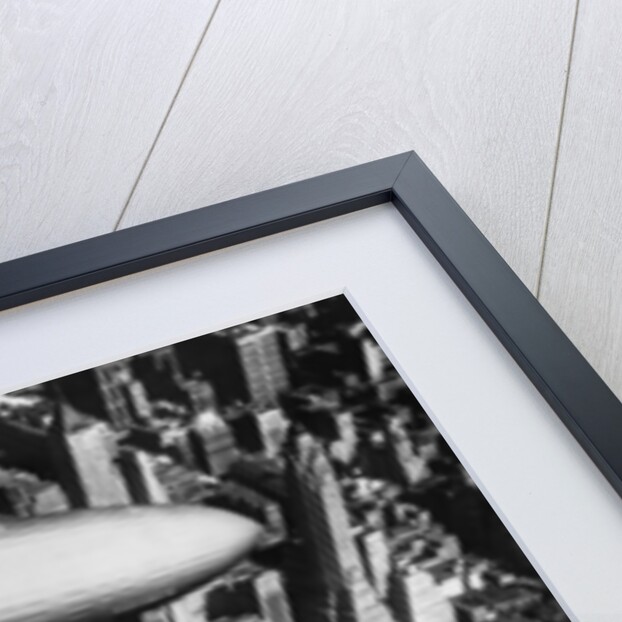 The German airship, the Hindenburg, above Manhattan, New York in 1936, on its way to its berth at Lakehurst , New Jersey, the same place where it inexplicably burst into flames the next year. by Anonymous