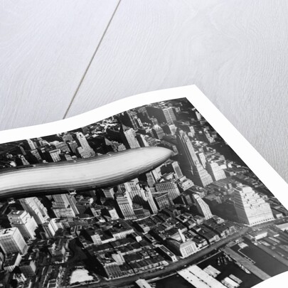 The German airship, the Hindenburg, above Manhattan, New York in 1936, on its way to its berth at Lakehurst , New Jersey, the same place where it inexplicably burst into flames the next year. by Anonymous