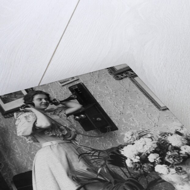 Woman Talking on Wall Mounted Telephone by Anonymous