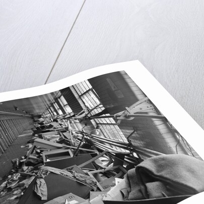 Damaged Furniture and Debris in Prison Hallway by Anonymous