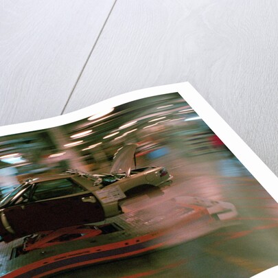 Partially Assembled Car Moving Through Work Station by Anonymous