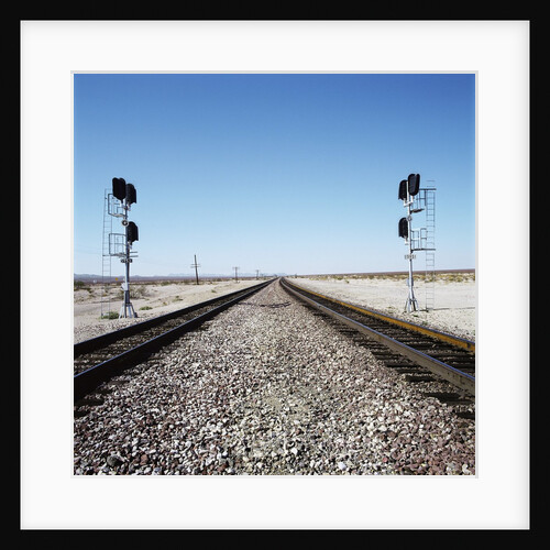 Railroad tracks running through desert setting by Anonymous