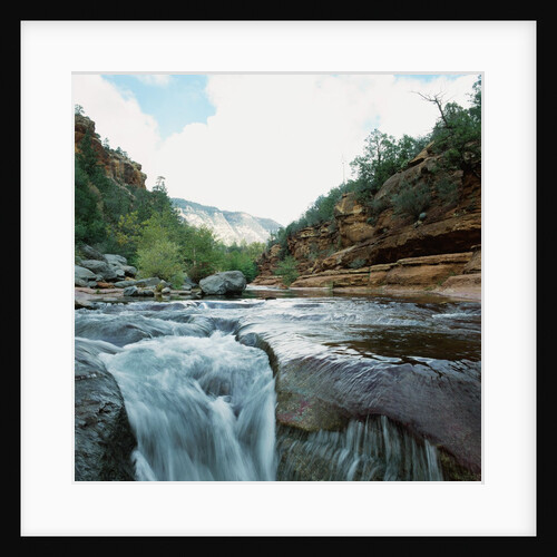 Low angle view of stream running through rural setting by Anonymous