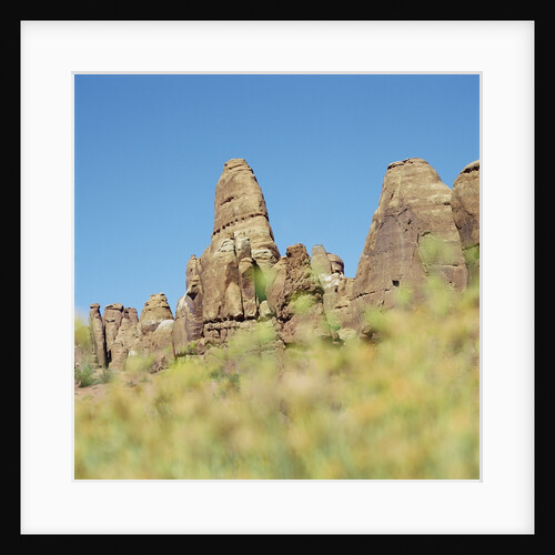 Low angle view of rock formations viewed through grass, Utah, USA by Anonymous