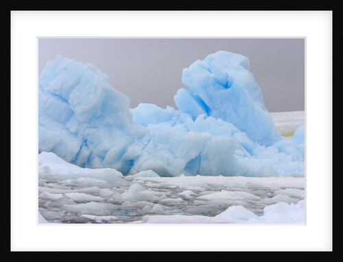 Blue Iceberg Floating Amid Ice Chunks by Anonymous