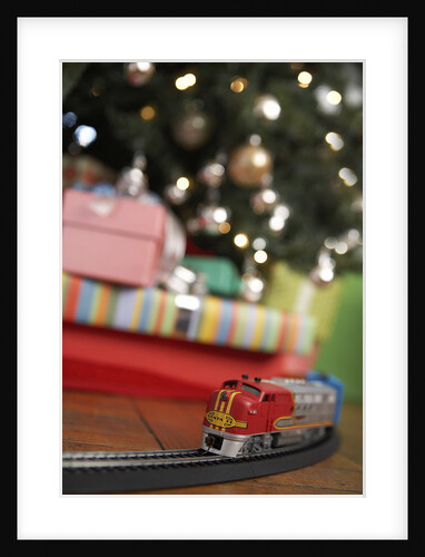 Toy train running beneath Christmas tree by Anonymous