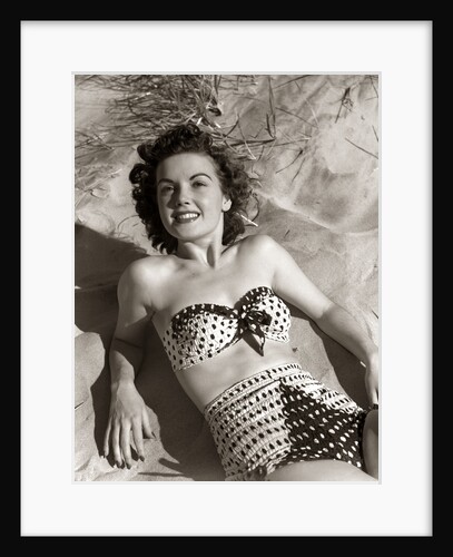 1950s Brunette Woman Wear Polka Dot Two Piece Bathing Suit Laying On Sand by Anonymous