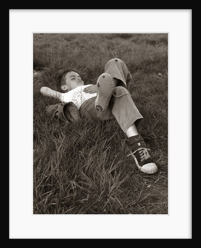 1960s Boy Sleeping In Grass Legs Crossed Holes In Sneakers Baseball Mitt By His Side by Anonymous