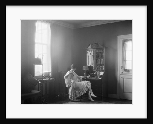 1920s Elegantly Dressed Woman Sitting At Desk Reading A Letter By Moody Window Light by Anonymous