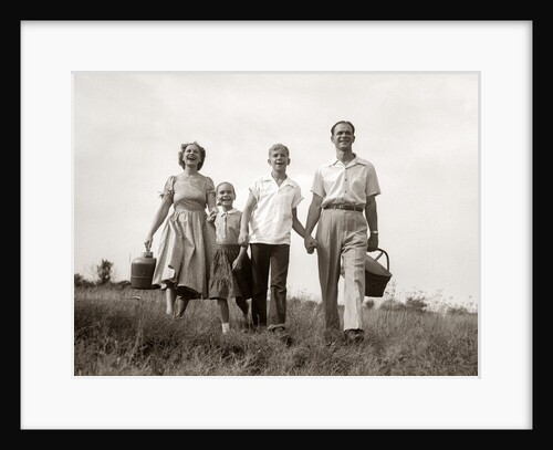 1950s Family Walking In Grassy Meadow Carrying Summer Picnic Basket And Thermos by Anonymous