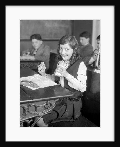 1920s School Girl Eating Lunch At Her Desk Drinking From A Bottle Of Milk Holding A Sandwich by Anonymous