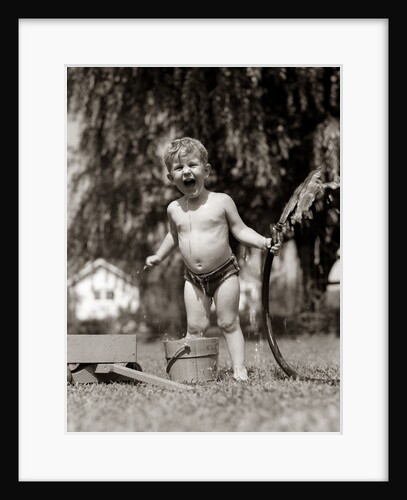 1940s 1950s Wet Young Boy Toddler Outside Playing With Water Hose by Anonymous