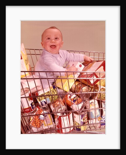1960s Happy Baby Sitting Inside Shopping Cart Full Of Groceries by Anonymous