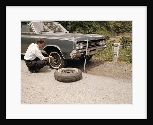 1960s Man Changing Flat Tire On Car At Side Of Rural Road Car Jack Tools Tire Iron by Anonymous