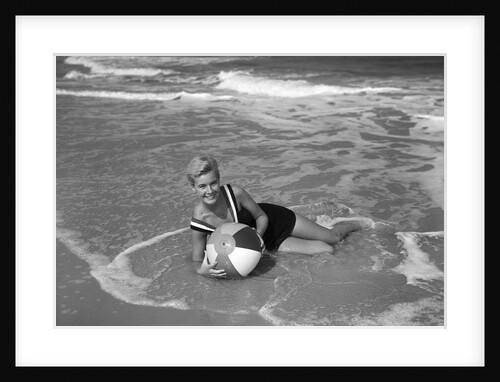 1960s Woman In Bathing Suit Lying In The Surf Holding A Beach Ball Outdoor by Anonymous