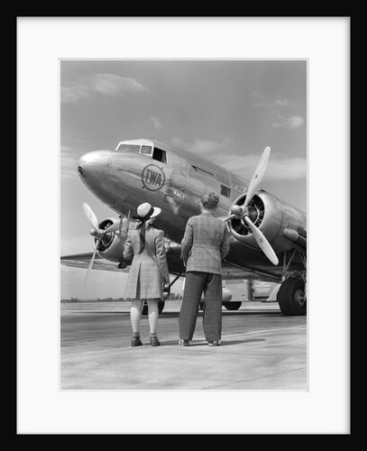 1940s Rear View Of Boy and Girl Standing Together Looking At Propeller Airplane Outdoor by Anonymous