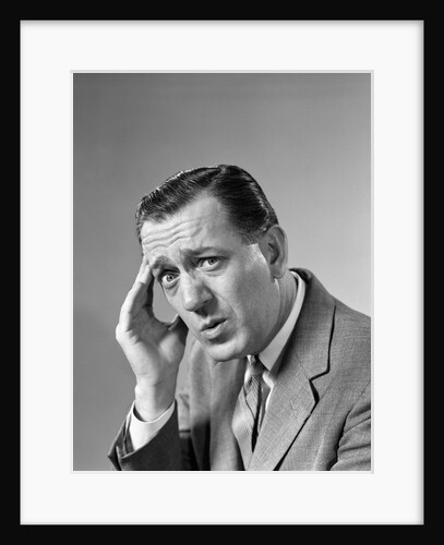 1960s Portrait Man In Suit and Tie With Wrinkled Brow Wincing and Holding Forehead by Anonymous