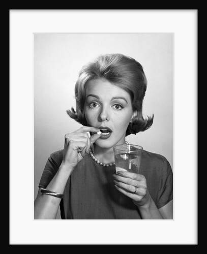 1960s Woman Taking Aspirin Pill Medicine by Anonymous