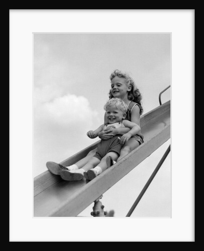 1950s 1960s Two Children Going Down Playground Slide by Anonymous