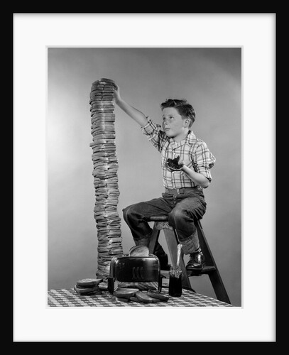 1950s Boy Eating Jelly Toast Sitting On Ladder Stacking Up Tall Pile Of Toast From Toaster by Anonymous
