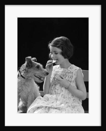 1920s 1930s Girl Eating Cookie With Dog by Anonymous