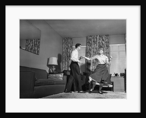 1950s Teen Couple Doing Jitterbug Rock And Roll Dance In Living Room Man Woman Boy Girl by Anonymous