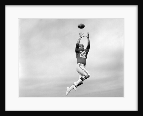1970s Player Jumping To Catch Football Pass by Anonymous