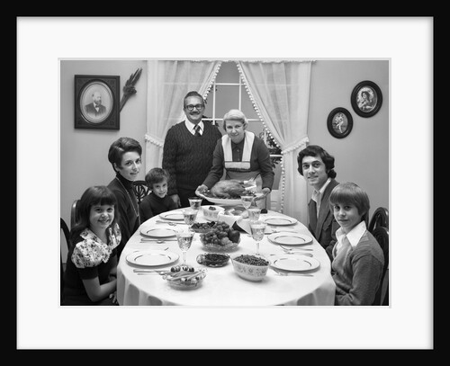 1970s 3 Generation Family Sitting Dining Room Table Grandmother Setting Down Turkey Platter by Anonymous