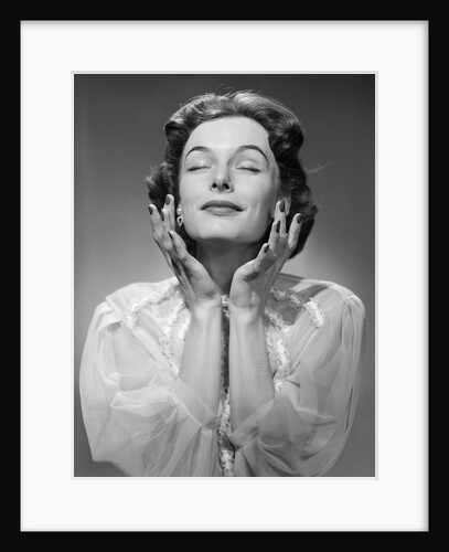 1950s Woman Wearing Peignoir With Eyes Closed Hands Held Near Face Ecstatic Facial Expression by Anonymous