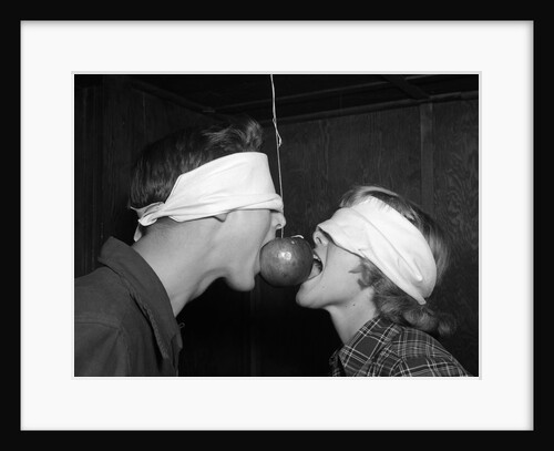1950s Blindfolded Couple Trying To Eat An Apple Hanging In Air From A String Inside by Anonymous