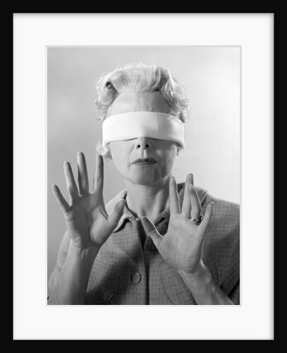 1960s Elderly Woman Wearing Blindfold Holding Up Her Hands by Anonymous