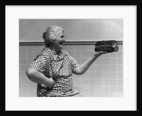1930s 1940s Grandmother In Apron Admiring Loaf Of Freshly Baked Bread by Anonymous