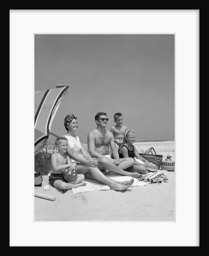 1960s Family Portrait Mother Father Daughter And Two Sons Sitting On Beach Under Umbrella by Anonymous