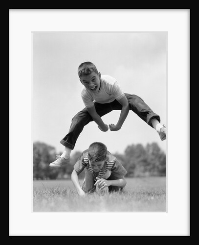 1960s Retro Boys Playing Leap Frog Outside Sky Grass Jump Jumping Crouching by Anonymous