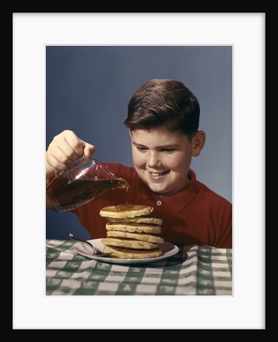 1950s 1960s Boy Pouring Syrup On Breakfast Pancakes by Anonymous