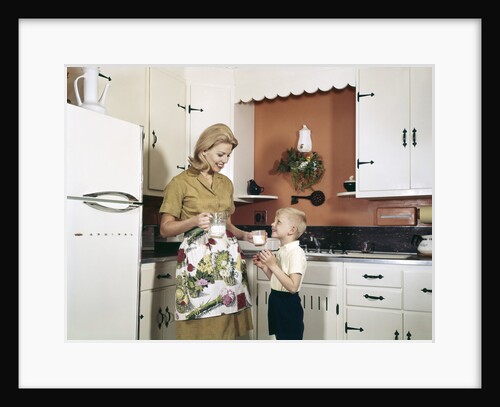 1970s Mother Handing Glass Of Milk To Son In Kitchen by Anonymous