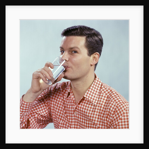 1960s Man Drinking Glass Water Wearing Red Checkered Shirt by Anonymous