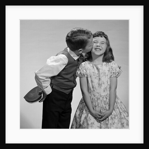 1950s 1960s Boy In Vest and Bow Tie Holding Valentine Candy Kissing Cheek Of Girl Making A Face by Anonymous